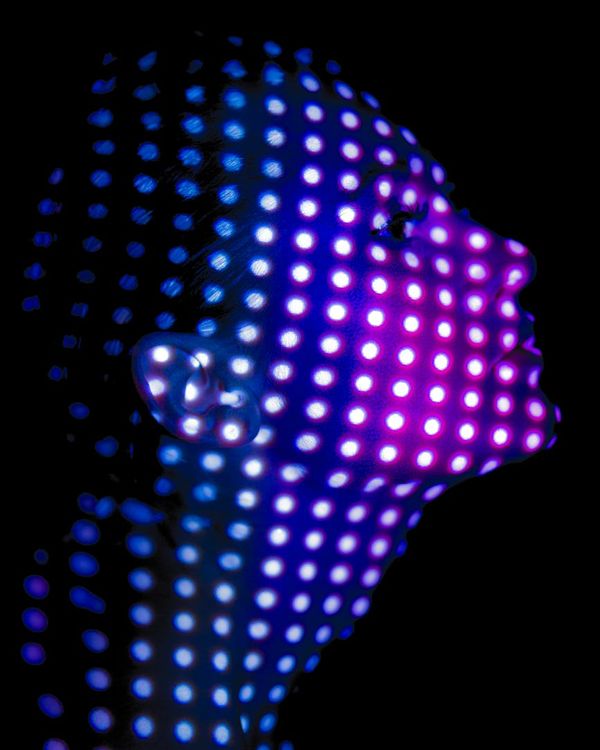 Person practicing a powerful yoga stance, illuminated by purple light.